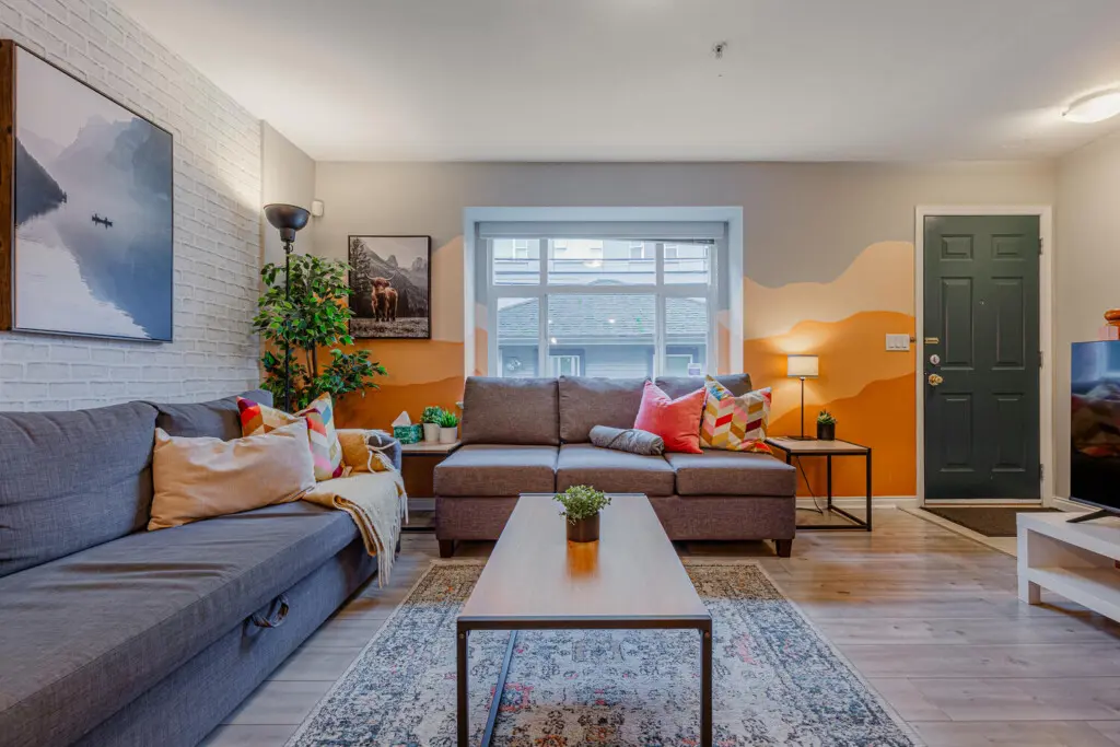 The living room offers plenty of comfortable seating, perfect for relaxing after a day of exploring. Bright accents and cozy textures create a warm, inviting space to unwind or gather with friends.