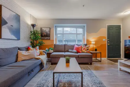 The living room offers plenty of comfortable seating, perfect for relaxing after a day of exploring. Bright accents and cozy textures create a warm, inviting space to unwind or gather with friends.