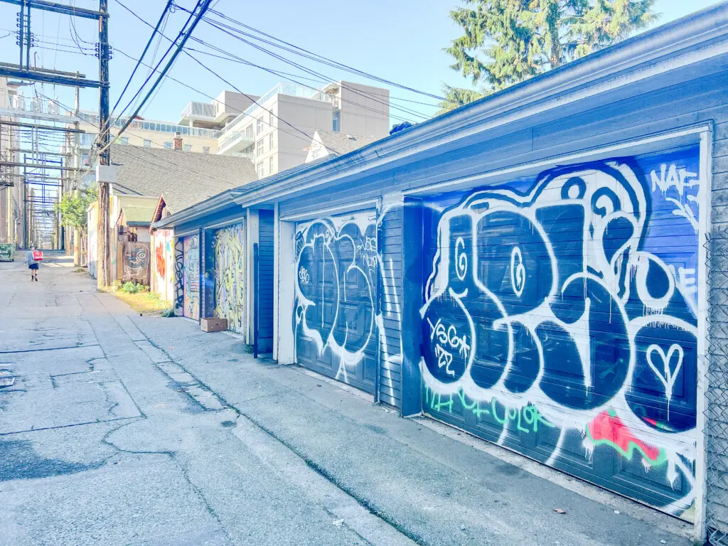 The colorful back alley adds an urban charm to the area, with one secure garage parking spot provided for guests — conveniently located second from the right.