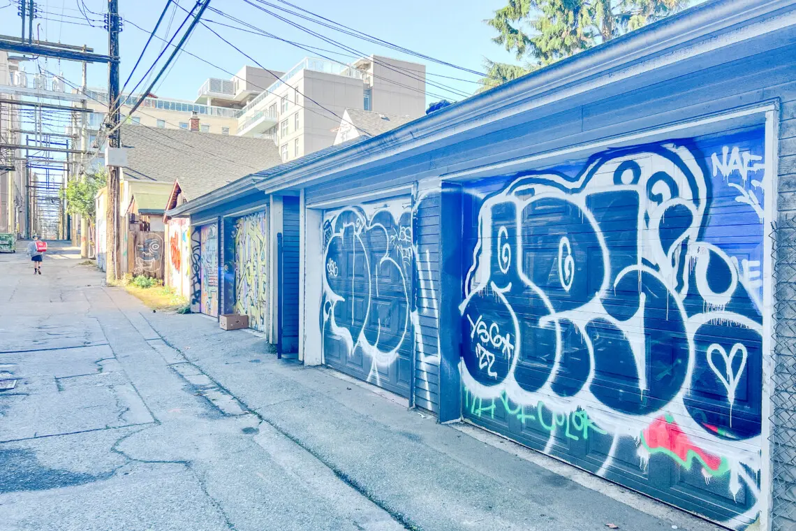 The colorful back alley adds an urban charm to the area, with one secure garage parking spot provided for guests — conveniently located second from the right.