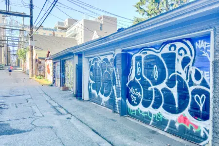 The colorful back alley adds an urban charm to the area, with one secure garage parking spot provided for guests — conveniently located second from the right.