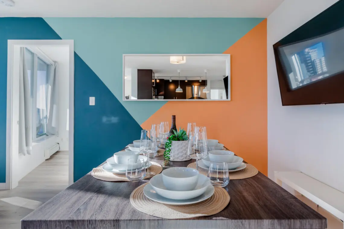 Gather around this beautifully set dining table for memorable meals and meaningful conversations. Framed by bold, modern accents and warm lighting, the space blends contemporary design with the inviting comfort of a true Vancouver urban stay.