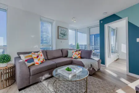 Filled with natural light, this stylish living space offers sweeping city views and a cozy retreat after a day of exploring Vancouver. The spacious sectional invites guests to relax and enjoy the blend of modern comfort and urban charm.