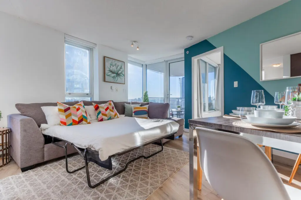 Designed for versatility, the spacious sectional easily converts into a comfortable queen-sized pull-out bed, ideal for additional guests. Bright, airy, and welcoming, it adds both function and style to this modern Vancouver suite.