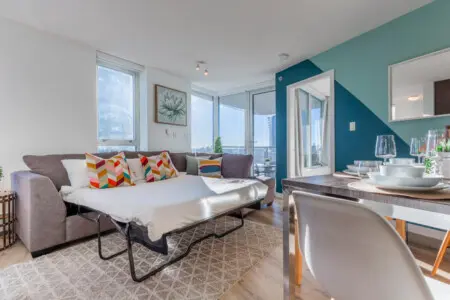 Designed for versatility, the spacious sectional easily converts into a comfortable queen-sized pull-out bed, ideal for additional guests. Bright, airy, and welcoming, it adds both function and style to this modern Vancouver suite.