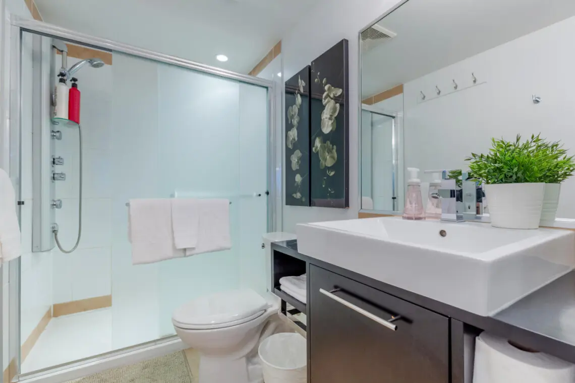 Clean lines and modern finishes define this bright, spa-inspired bathroom. Featuring a glass-enclosed shower, sleek vanity, and calming décor, it offers guests a refreshing retreat after a day exploring Vancouver.