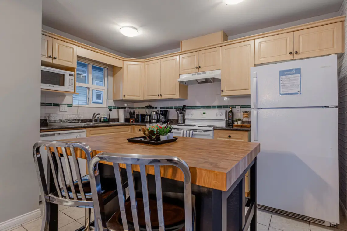 The spacious kitchen island serves as a perfect breakfast spot, offering ample counter space for food prep and casual dining.