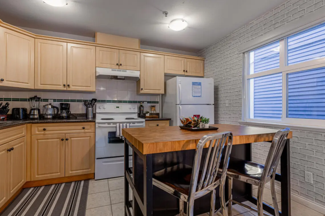 The spacious kitchen island offers a perfect spot to enjoy breakfast or a quick snack. Bright and fully equipped, this inviting space makes dining and meal prep feel effortless and homey.