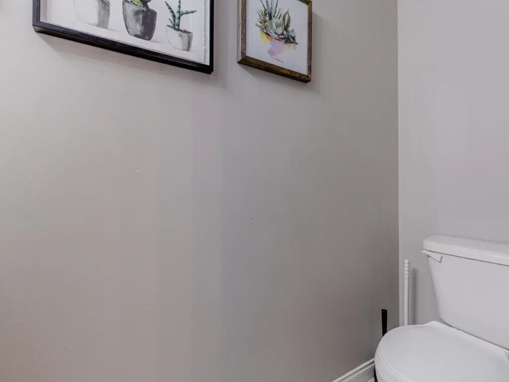 The main-floor half bathroom offers a clean, modern space accented with simple décor — a convenient touch for guests during their Vancouver stay.