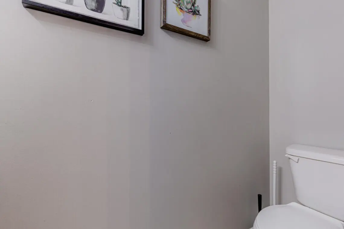 The main-floor half bathroom offers a clean, modern space accented with simple décor — a convenient touch for guests during their Vancouver stay.