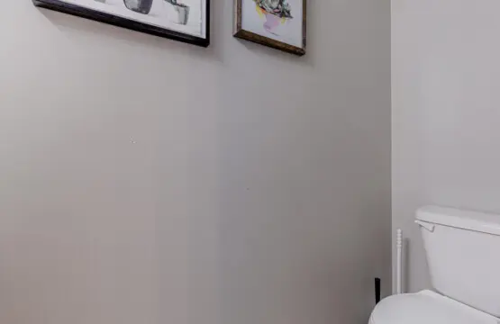 The main-floor half bathroom offers a clean, modern space accented with simple décor — a convenient touch for guests during their Vancouver stay.