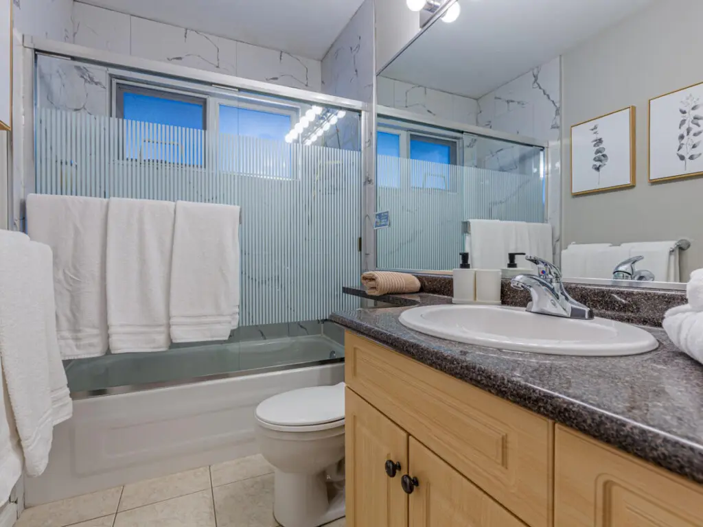 The second-floor full bathroom features a sleek vanity, bright lighting, and a shower-tub combo — offering both comfort and convenience during your Vancouver stay.