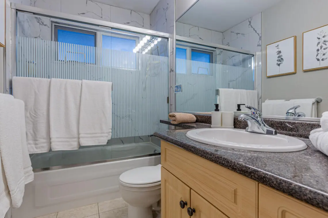 The second-floor full bathroom features a sleek vanity, bright lighting, and a shower-tub combo — offering both comfort and convenience during your Vancouver stay.