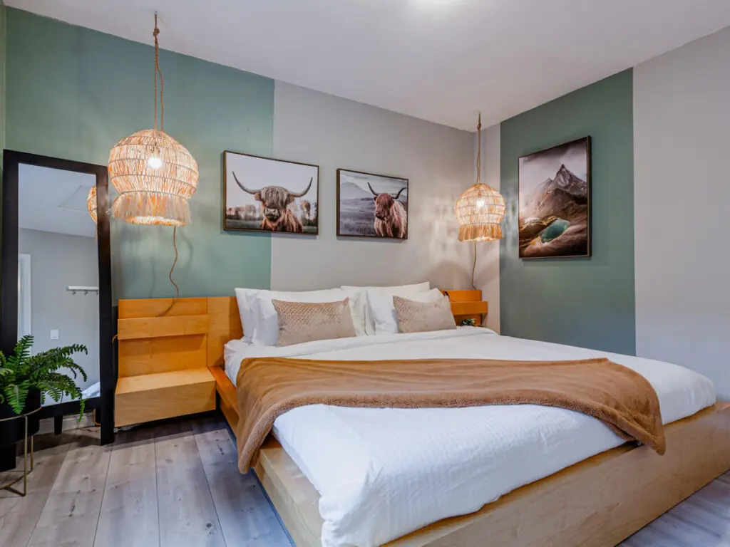 The primary bedroom features a plush king bed with soft linens and blackout blinds for a restful night’s sleep. Thoughtful details and warm lighting create a calm, inviting retreat to unwind in comfort.
