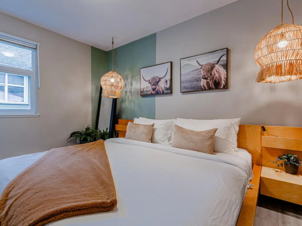 The main bedroom features a spacious king bed with soft lighting and warm accents — a cozy retreat for restful nights during your Vancouver stay.