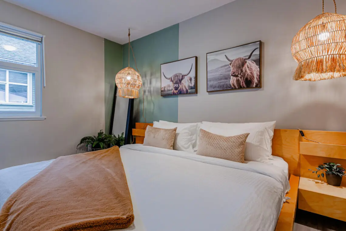 The main bedroom features a spacious king bed with soft lighting and warm accents — a cozy retreat for restful nights during your Vancouver stay.