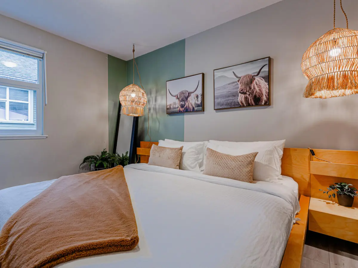The main bedroom features a spacious king bed with soft lighting and warm accents — a cozy retreat for restful nights during your Vancouver stay.