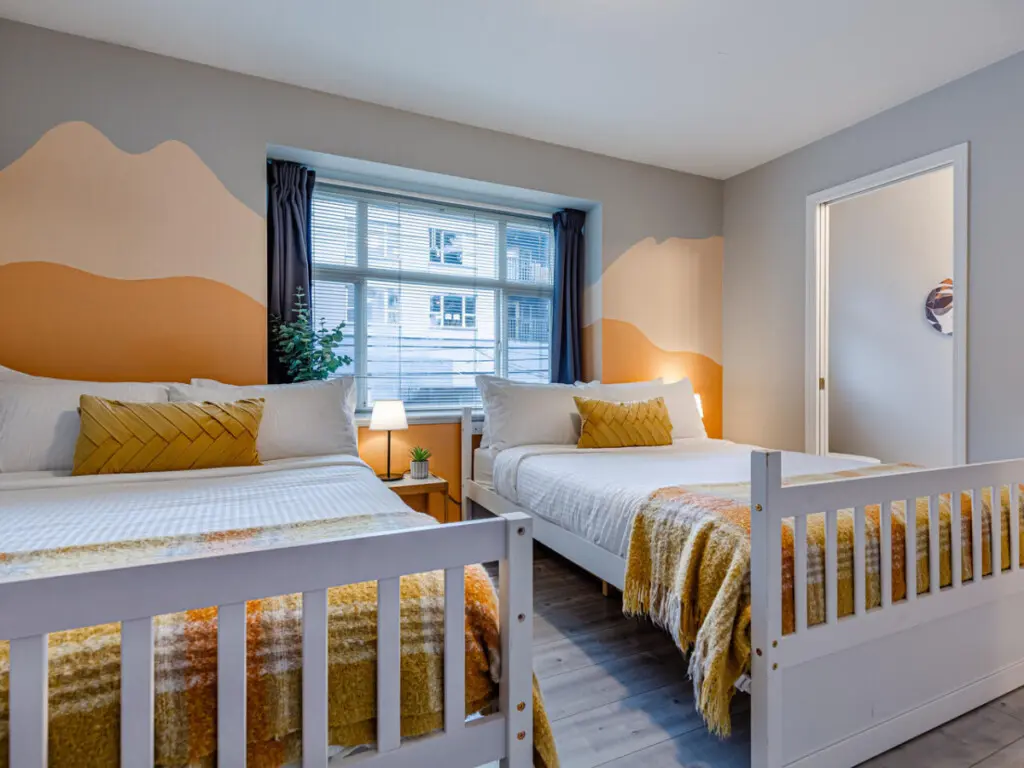 The second bedroom features two double beds and blackout curtains, offering a restful night’s sleep and a bright, cheerful space to start the day refreshed.