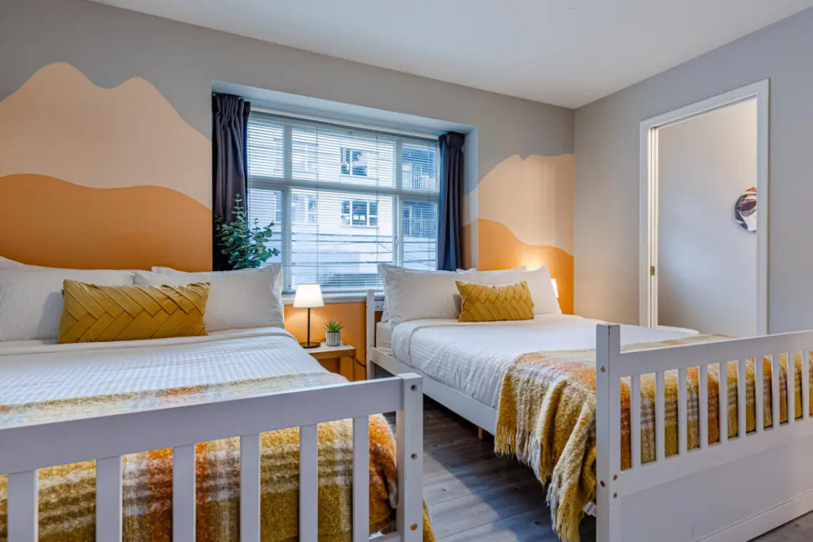 The second bedroom features two double beds and blackout curtains, offering a restful night’s sleep and a bright, cheerful space to start the day refreshed.