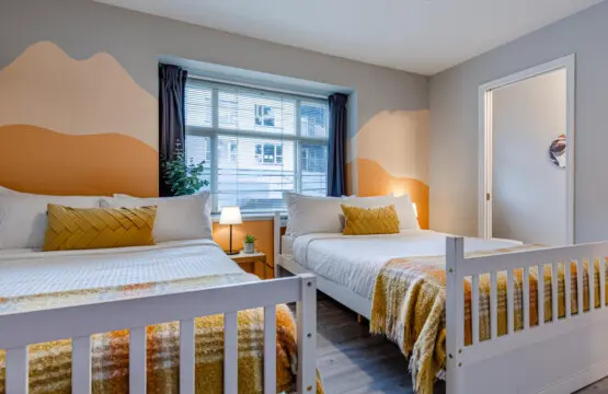 The second bedroom features two double beds and blackout curtains, offering a restful night’s sleep and a bright, cheerful space to start the day refreshed.