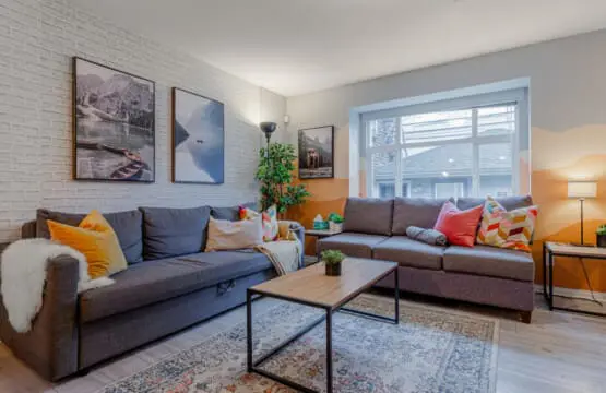 The bright, welcoming living room offers plenty of comfortable seating — perfect for relaxing, socializing, or unwinding after a day out in the city.