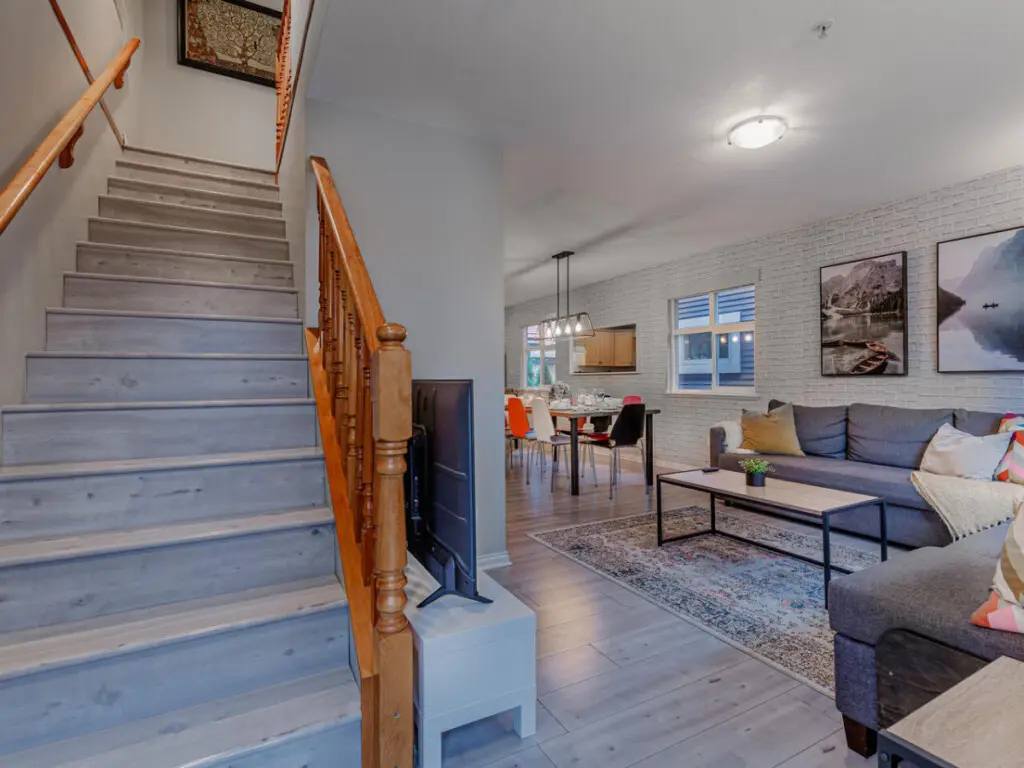 The staircase leads from the open living area to the private upstairs bedrooms, seamlessly connecting shared spaces with restful retreats.