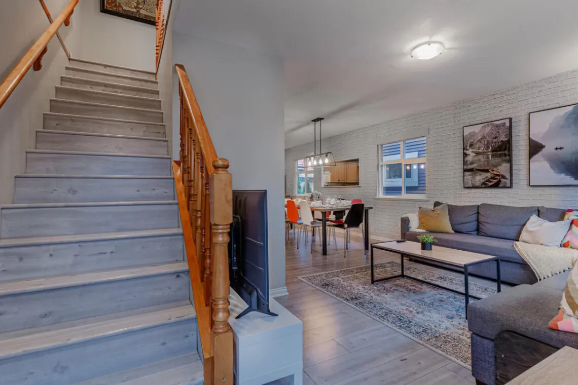 The staircase leads from the open living area to the private upstairs bedrooms, seamlessly connecting shared spaces with restful retreats.