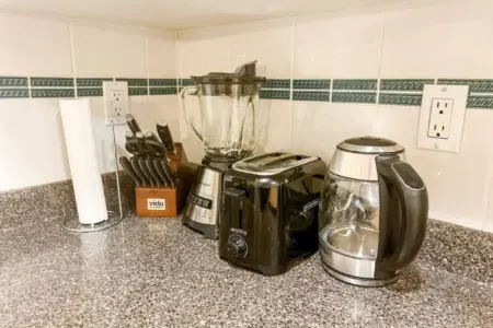 The kitchen comes fully equipped with a complete knife set, high-power blender, toaster, and electric kettle — everything guests need for easy meal prep and morning routines.