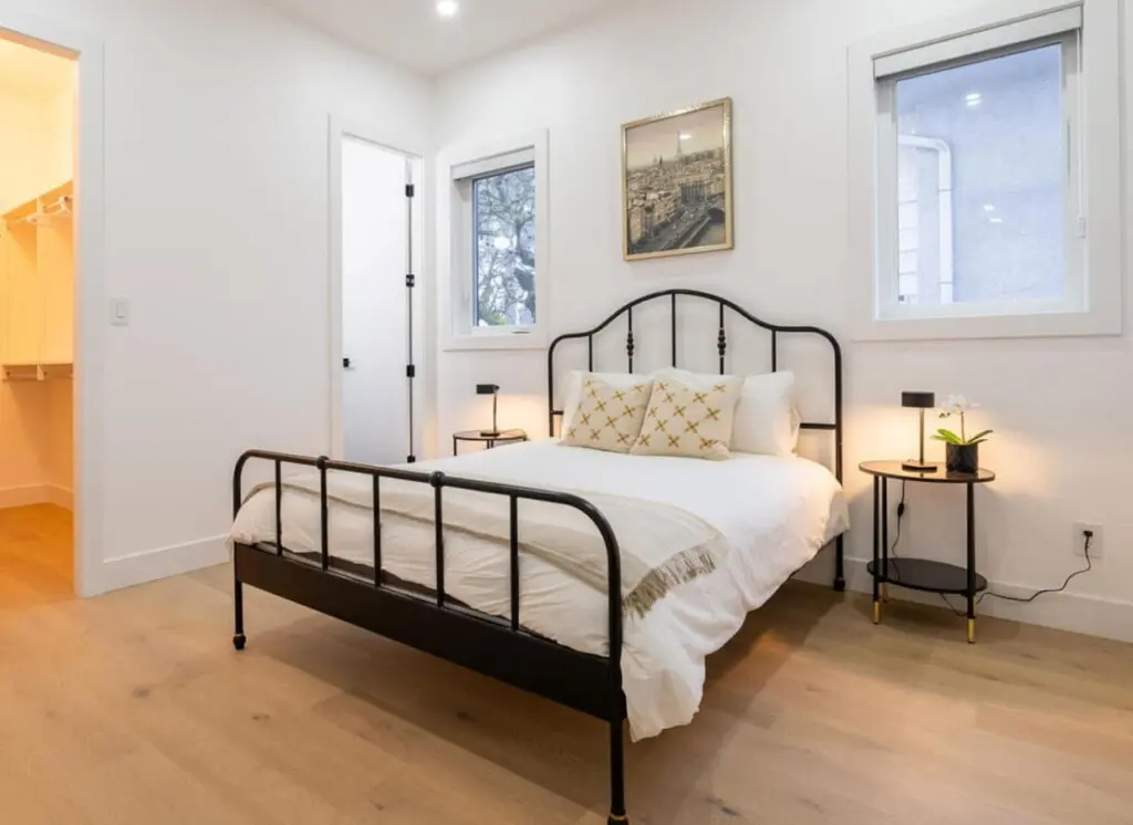 Located on the main floor, this inviting bedroom features a plush queen bed, soft lighting, and a soothing neutral palette. With its warm ambiance and modern furnishings, it offers guests a restful space to unwind and enjoy a peaceful night’s sleep.