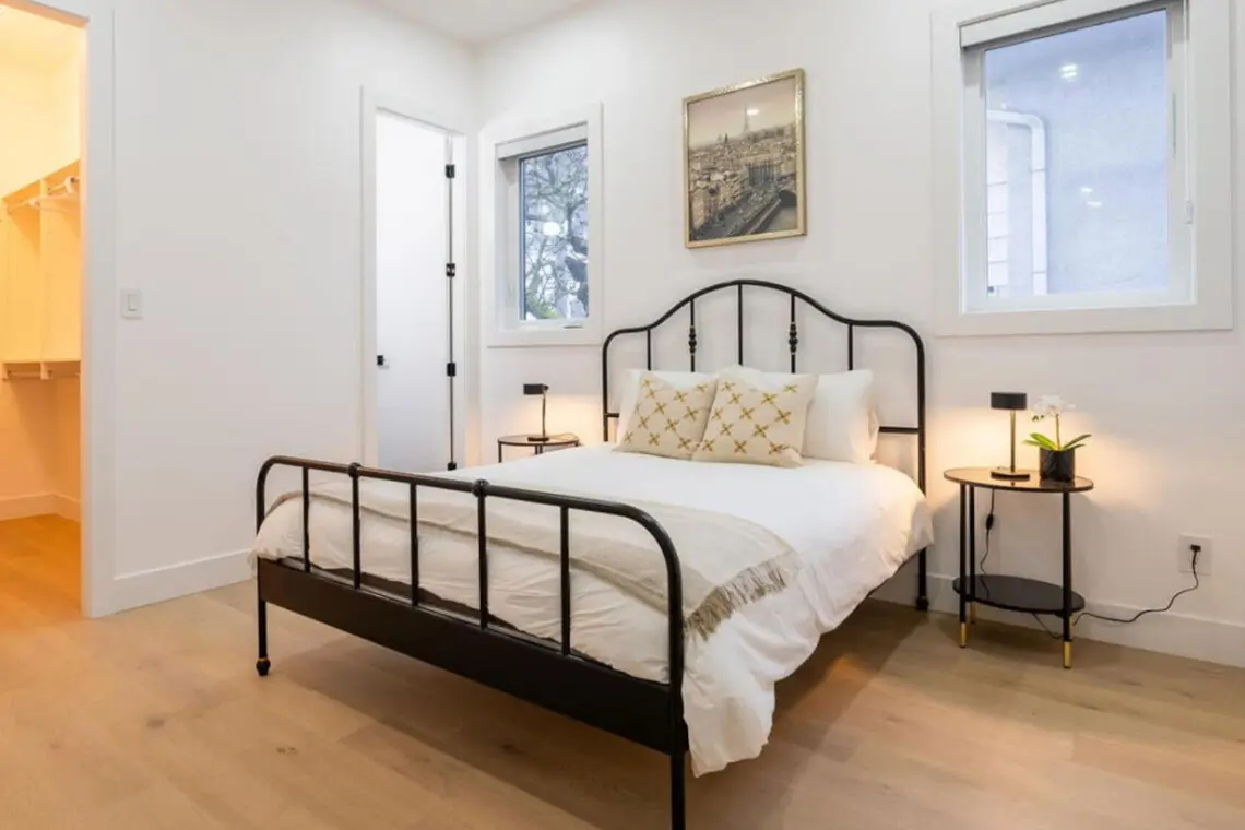 Located on the main floor, this inviting bedroom features a plush queen bed, soft lighting, and a soothing neutral palette. With its warm ambiance and modern furnishings, it offers guests a restful space to unwind and enjoy a peaceful night’s sleep.