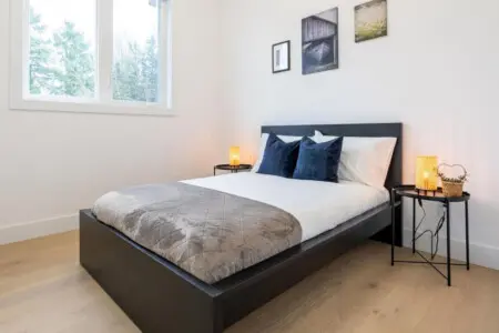 Located on the main floor, this cozy bedroom features a comfortable double bed and warm, modern décor. Though it’s the only room without an ensuite, the conveniently located powder room just across the hall ensures comfort and ease during your stay.