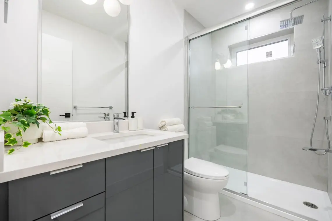 This sleek ensuite bathroom combines privacy and modern comfort with its spacious glass shower, elegant vanity, and calming neutral tones. Thoughtfully designed for convenience, it provides a refreshing retreat connected to the third bedroom.