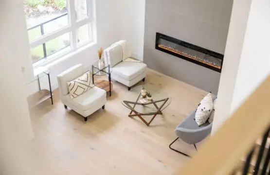 A view from the upstairs foyer reveals the inviting front sitting area, complete with a modern fireplace and cozy seating. Bathed in natural light, it’s the perfect spot to relax and unwind in your home away from home.