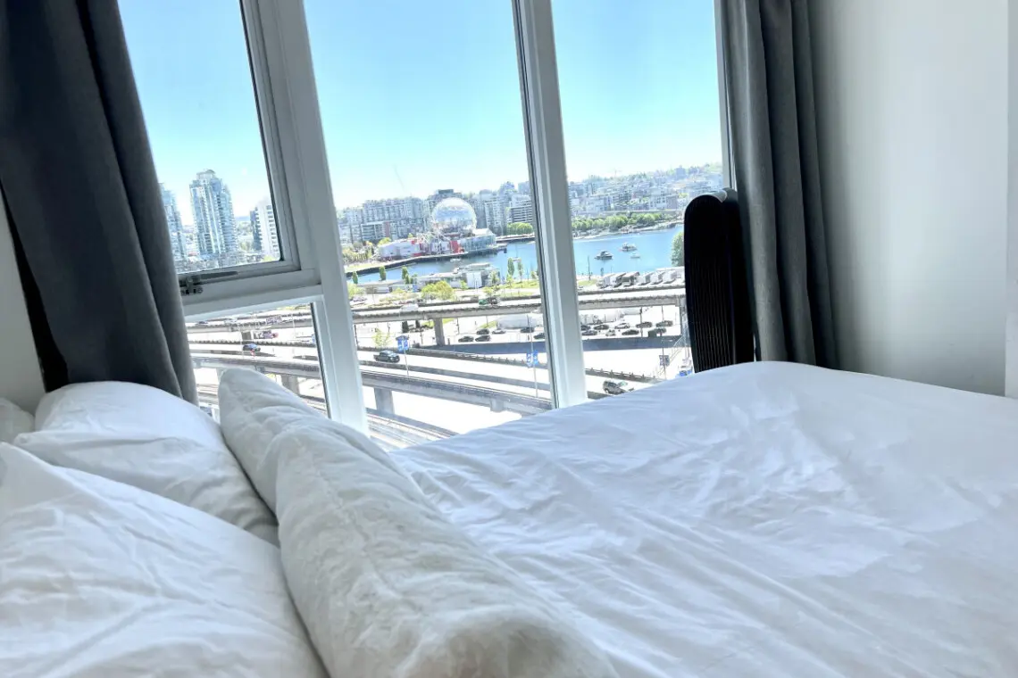 Wake up to breathtaking city and waterfront views from this bright bedroom — a peaceful spot to start and end your day in modern Vancouver comfort.