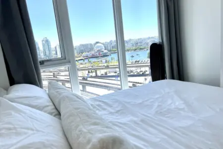 Wake up to breathtaking city and waterfront views from this bright bedroom — a peaceful spot to start and end your day in modern Vancouver comfort.