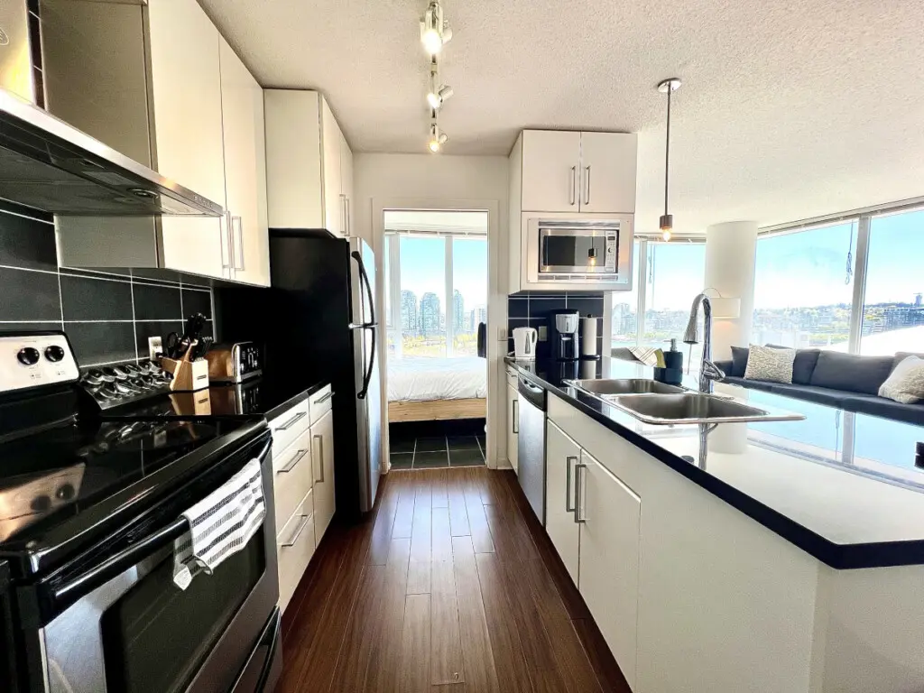Prepare and share meals with ease in this sleek, open-concept kitchen — featuring modern appliances, spacious countertops, and bright city views that inspire connection.