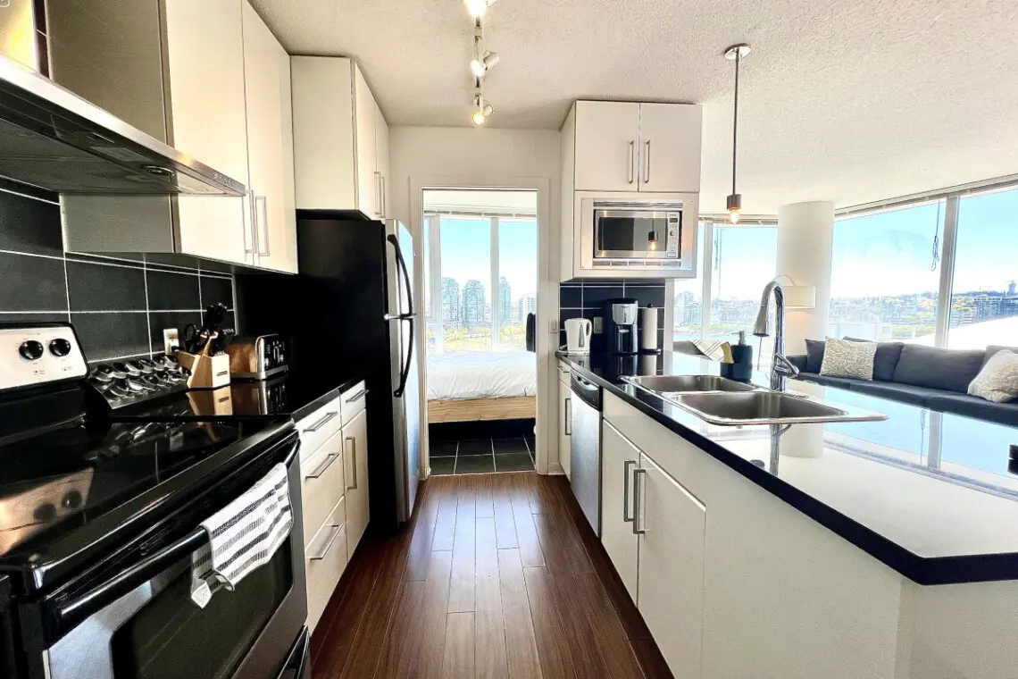 Prepare and share meals with ease in this sleek, open-concept kitchen — featuring modern appliances, spacious countertops, and bright city views that inspire connection.