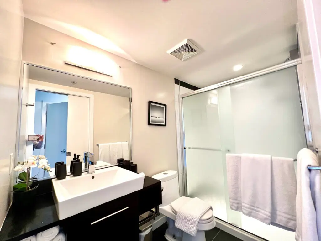 Fresh and modern, this full bathroom offers a sleek design with a spacious vanity, glass-enclosed shower, and soft towels — creating a bright and calming space to refresh and unwind.