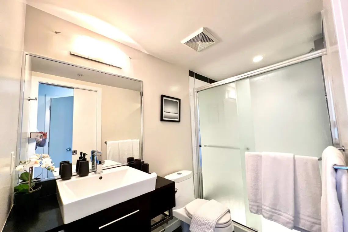 Fresh and modern, this full bathroom offers a sleek design with a spacious vanity, glass-enclosed shower, and soft towels — creating a bright and calming space to refresh and unwind.