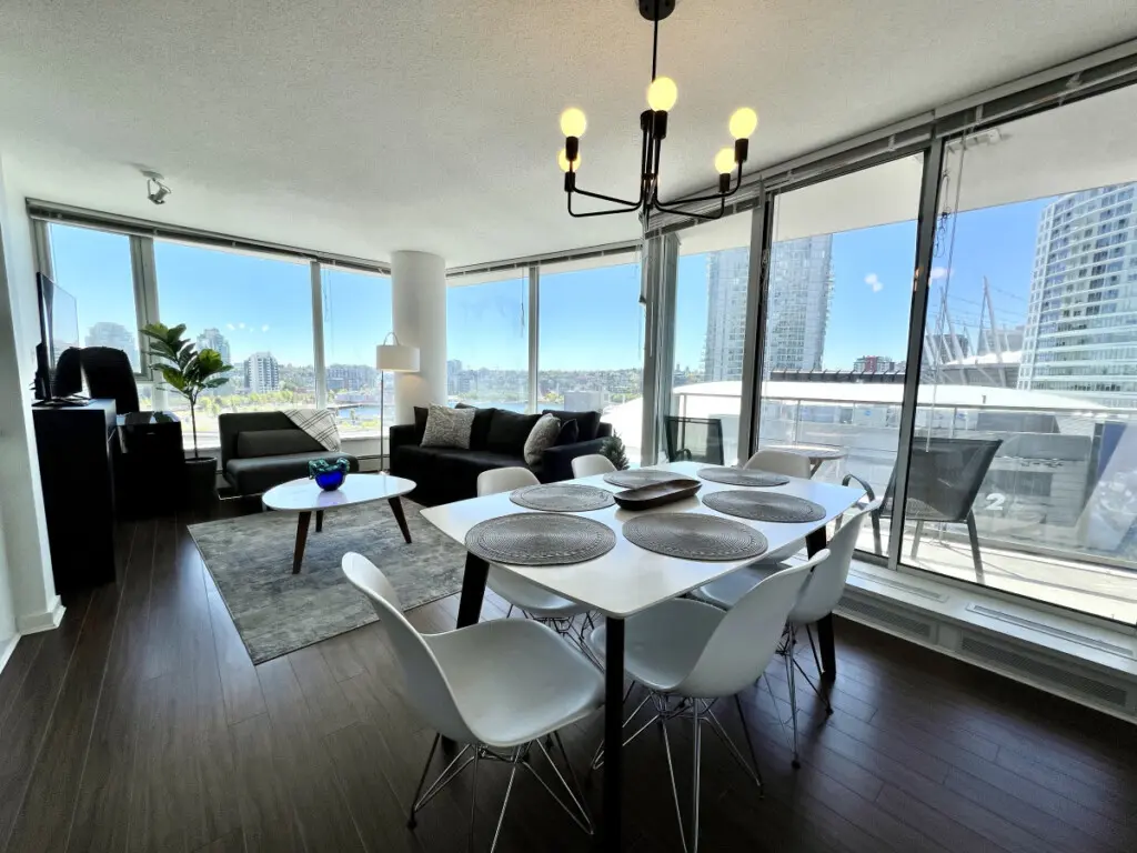 Gather for meals and conversation in this bright, open-concept living and dining area, where floor-to-ceiling windows frame stunning city and waterfront views.