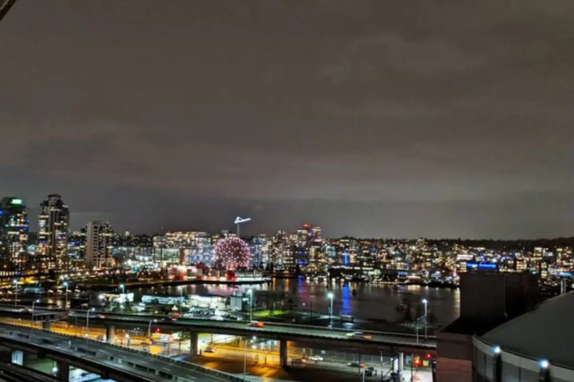 Take in the dazzling night skyline of Vancouver, where city lights reflect over the water — a breathtaking view right from your furnished suite.
