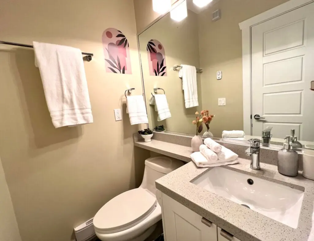 Modern and sleek, this first-floor full bathroom offers a bright, well-appointed space complete with fresh towels and contemporary finishes for added comfort.