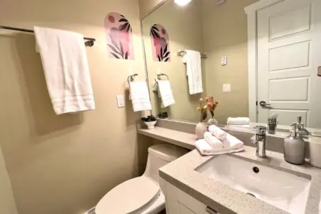 Modern and sleek, this first-floor full bathroom offers a bright, well-appointed space complete with fresh towels and contemporary finishes for added comfort.