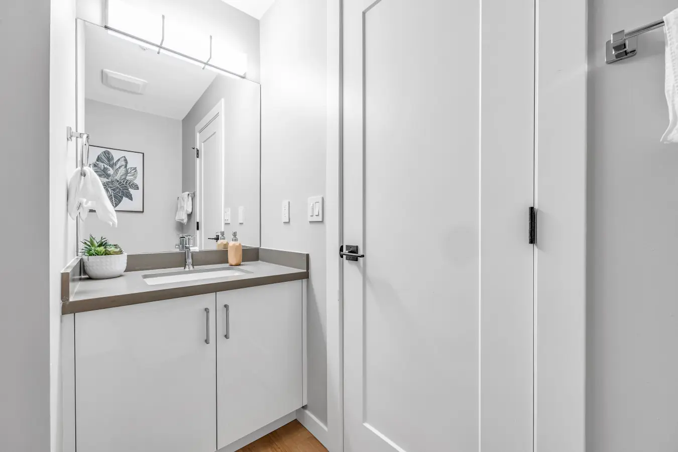 A bright and modern bathroom featuring sleek cabinetry, a wide mirror, and elegant finishes — a refreshing space to start the morning or unwind at the end of the day.