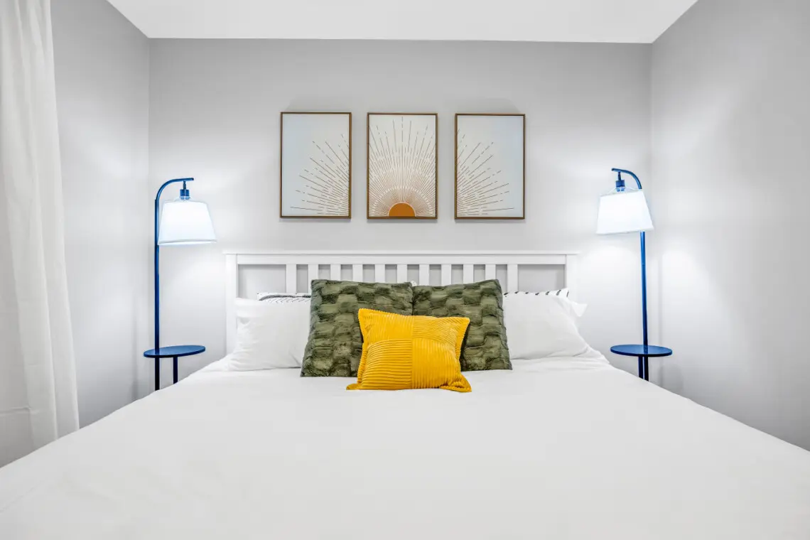 A bright and welcoming bedroom designed for relaxation, featuring a plush bed, soft textures, and calming décor. Thoughtful details and warm tones create a cozy, restful haven that instantly feels like home.