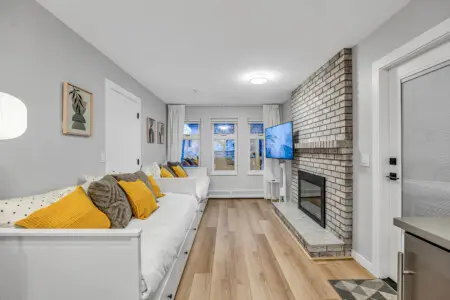 A cozy space for relaxation, featuring twin daybeds that convert into king-size beds — perfect for unwinding by the fireplace after a day of exploring Vancouver.