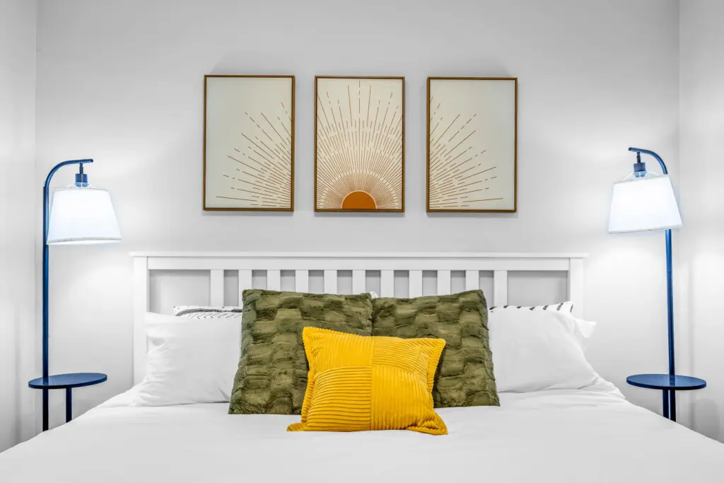 A bright and restful bedroom designed for deep relaxation — featuring soft linens, plush pillows, and warm, golden accents that make it easy to unwind, drift off, and wake up refreshed for another beautiful day in Vancouver.