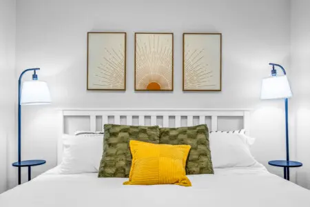 A bright and restful bedroom designed for deep relaxation — featuring soft linens, plush pillows, and warm, golden accents that make it easy to unwind, drift off, and wake up refreshed for another beautiful day in Vancouver.