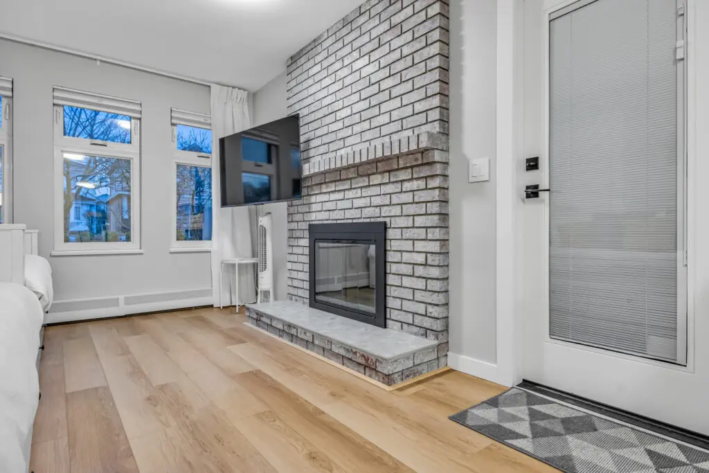 A welcoming living space where comfort meets calm — featuring a modern fireplace, warm wood floors, and soft natural light. Perfect for quiet mornings, movie nights, or simply unwinding after a day of exploring Vancouver.