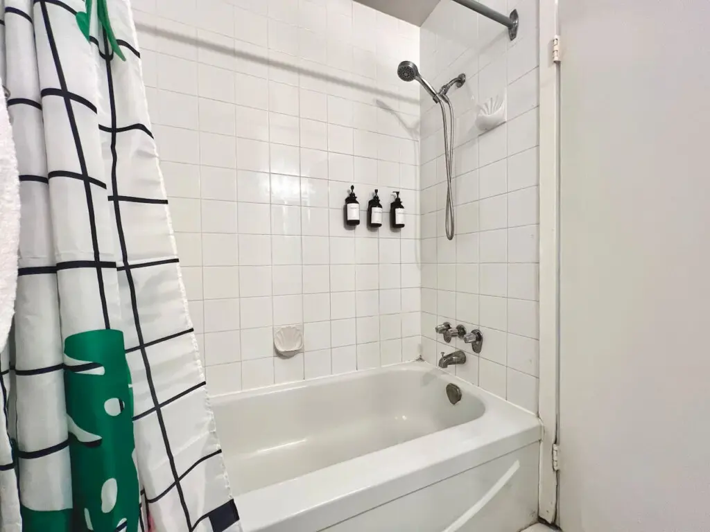 A clean, modern bathtub and shower setup complete with essential toiletries — perfect for refreshing mornings or unwinding after a day exploring Vancouver.